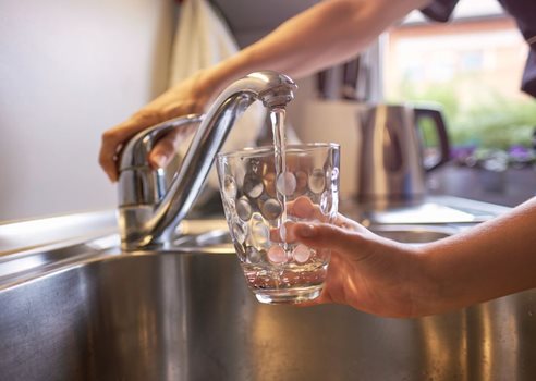 2025 Person Fylder Et Drikkeglas Med Klart Vand Fra Vandhanen Ved En Køkkenvask Adobe Stock